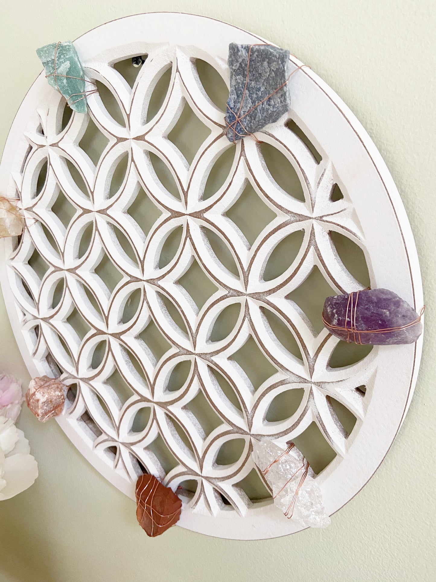 Decorative white lattice tray with crystals on a light green background