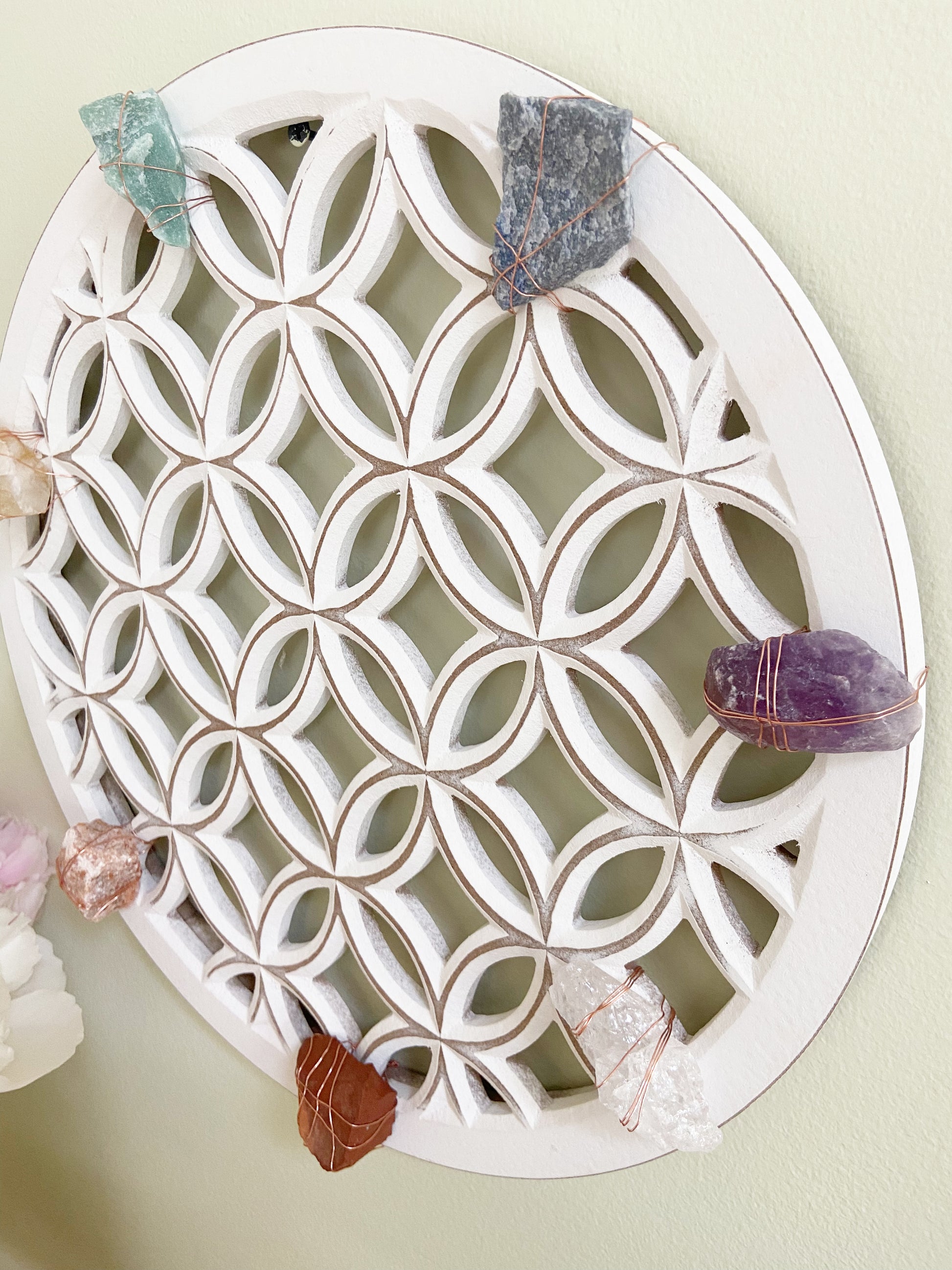Decorative white lattice tray with crystals on a light green background