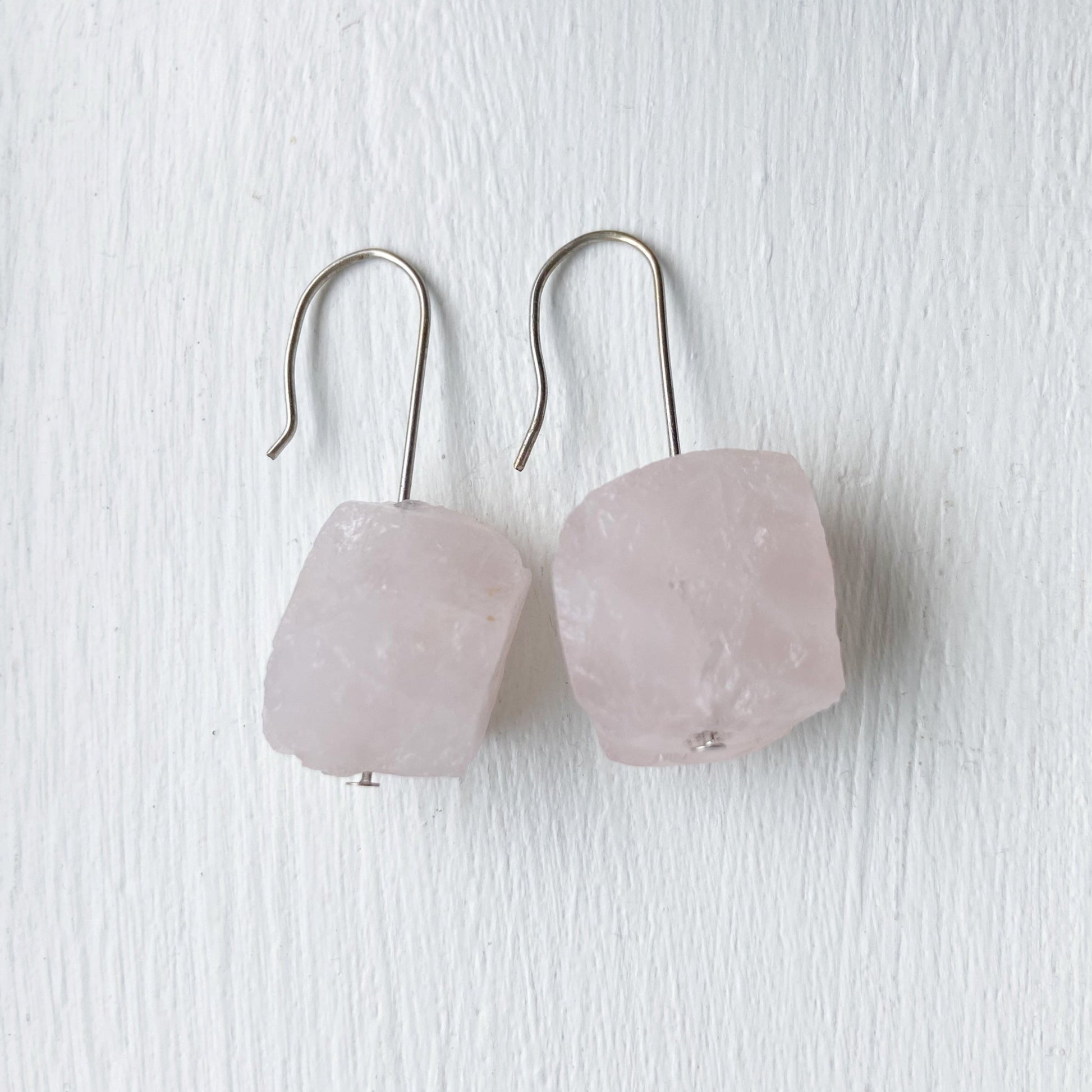 Pair of pink crystal earrings on a white surface