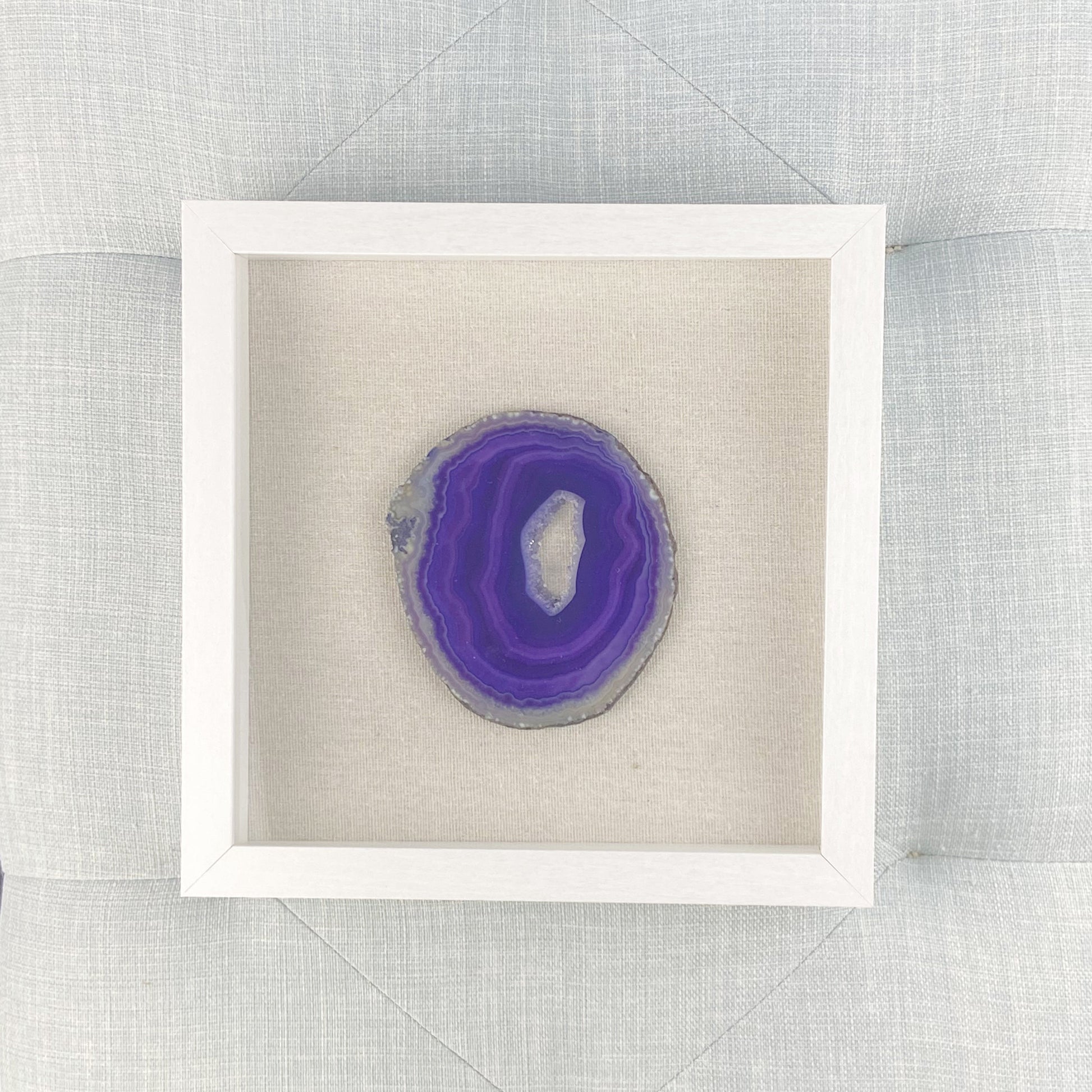 Framed purple agate stone on a textured gray background