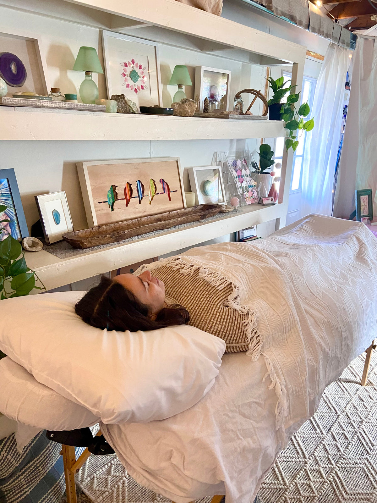 Client relaxing under a blanket on the Reiki table at Soul Illumination with Danra's Waterbury, VT studio